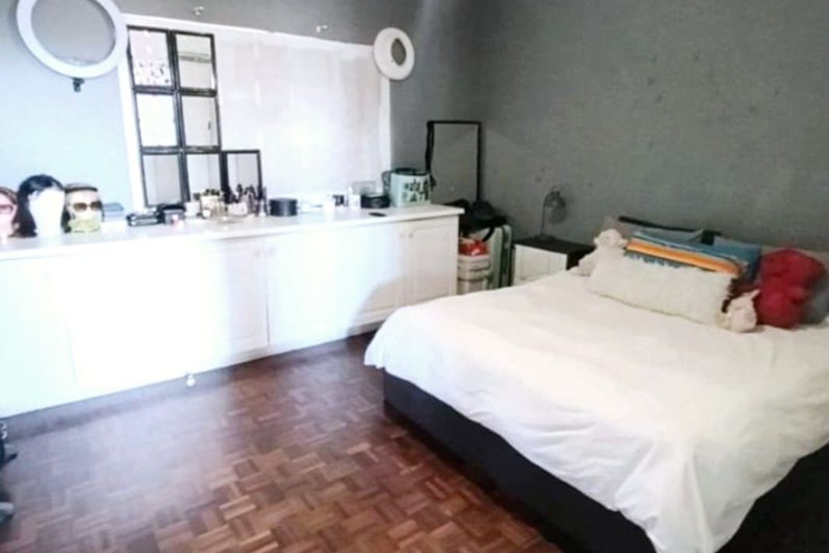 A bedroom featuring parquet flooring, built-in cabinetry, and coved ceilings, offering a functional space with potential for cosmetic updates.