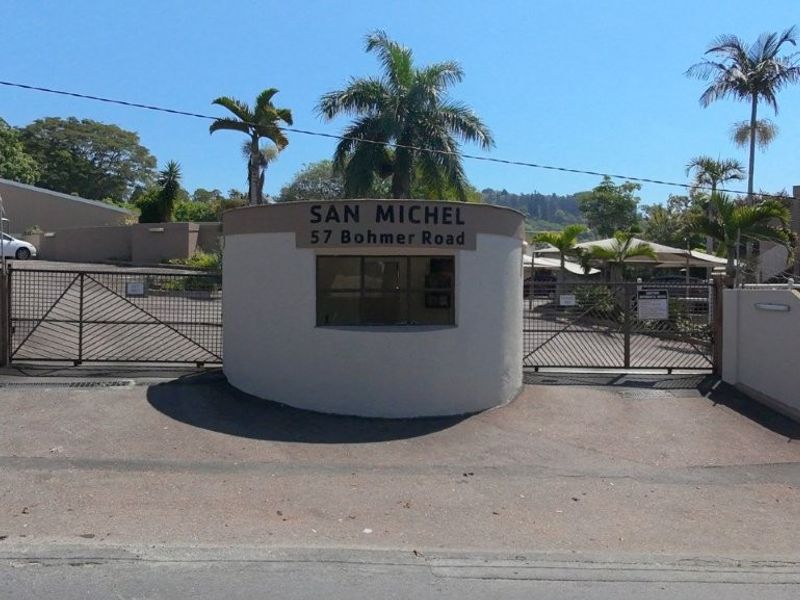 The secure gated entrance to San Michel complex on Bohmer Road, featuring a guard house and automated vehicle access gates.