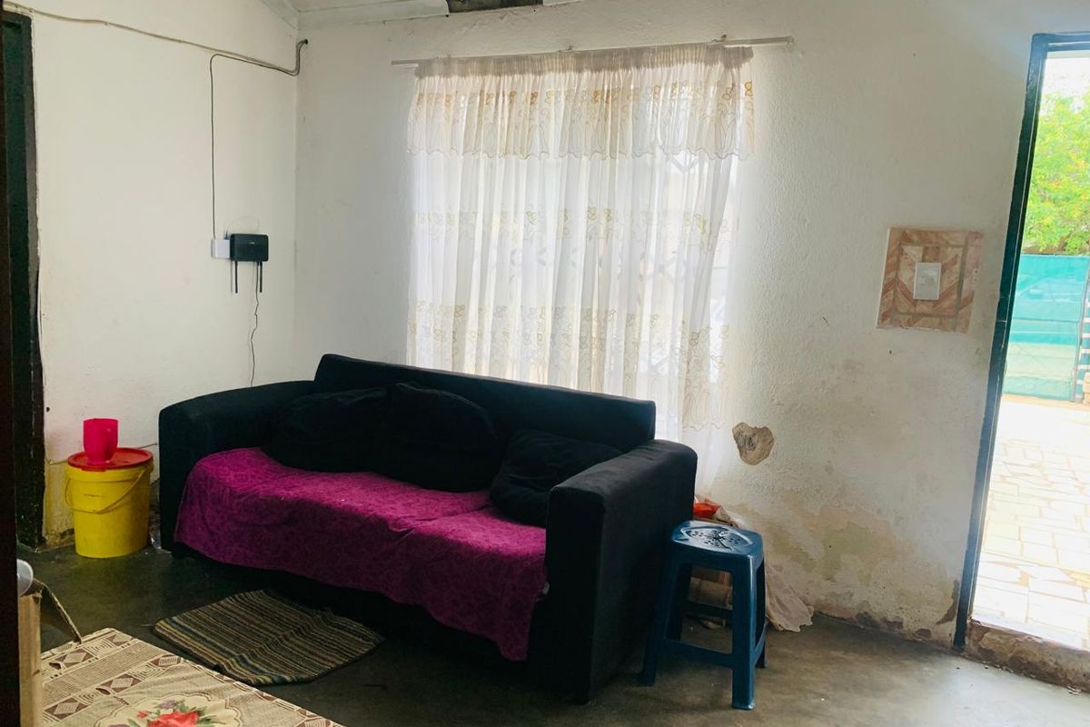 A living room area showing significant wall and ceiling damage, requiring plaster repair and repainting to restore the space.