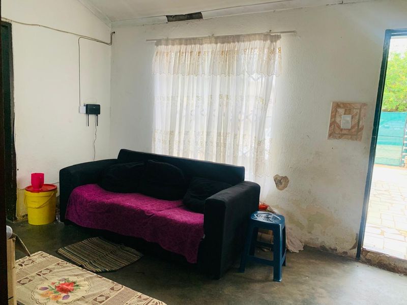 A living room area showing significant wall and ceiling damage, requiring plaster repair and repainting to restore the space.