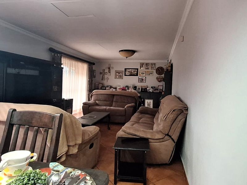 A spacious living room featuring tiled flooring and neutral wall finishes, offering a comfortable and functional layout for family relaxation.