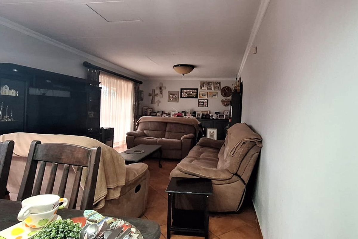 A spacious living room featuring tiled flooring and neutral wall finishes, offering a comfortable and functional layout for family relaxation.