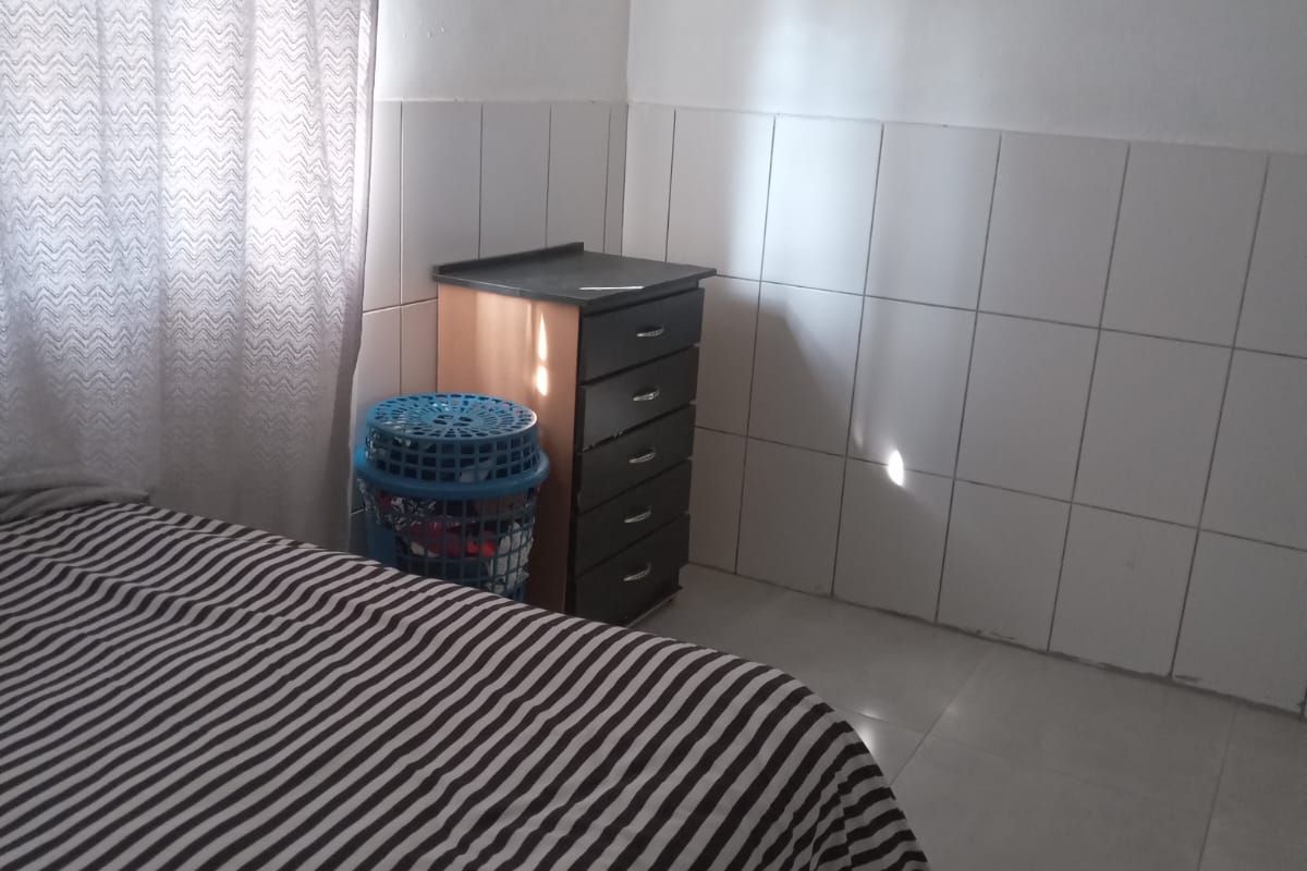 A bedroom featuring tiled walls and flooring, providing a functional and easy-to-maintain space.