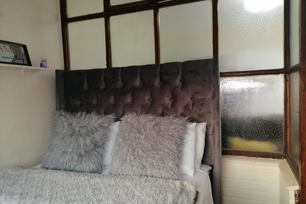 A bedroom featuring a distinctive timber-framed glass partition wall, providing a unique architectural element to the space.