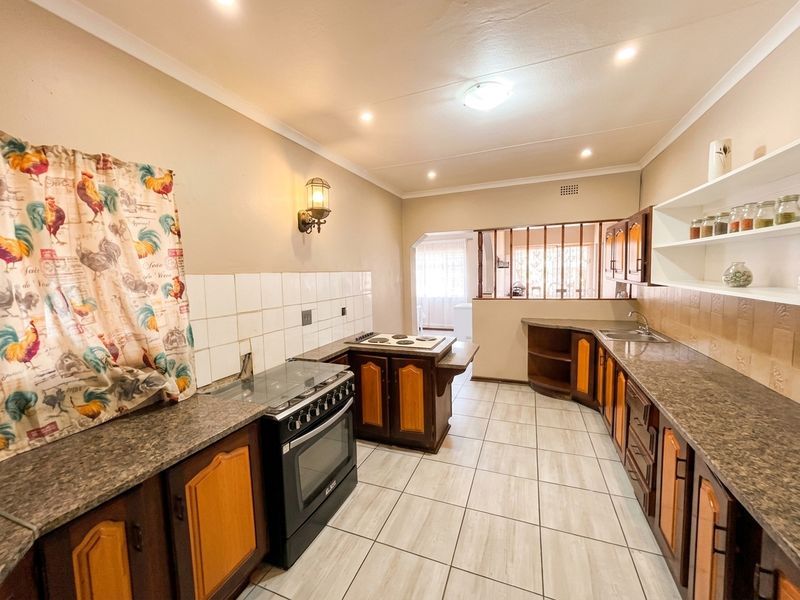 Functional kitchen featuring laminate countertops, built-in cabinetry, tiled backsplash, and a freestanding stove, offering a practical layout with ample storage space.