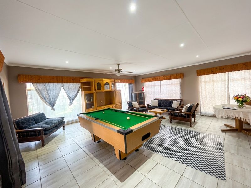 Spacious living area featuring tiled flooring, recessed downlights, and a ceiling fan, offering a versatile space for relaxation and entertainment.