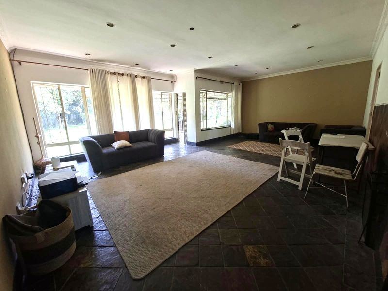 Spacious living area featuring slate tile flooring, recessed downlighting, and large windows that provide ample natural light.