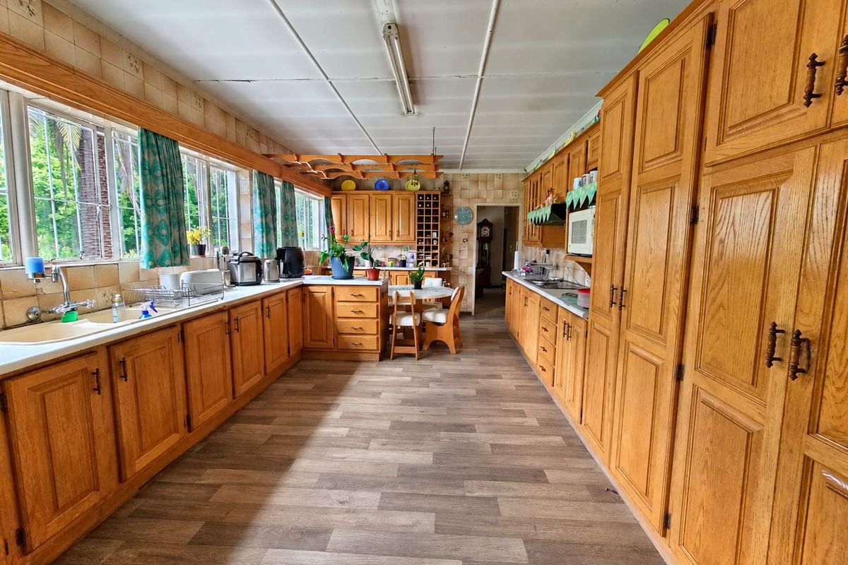 Spacious kitchen featuring extensive wooden cabinetry, laminate flooring, and a functional layout with ample counter space and integrated appliances.