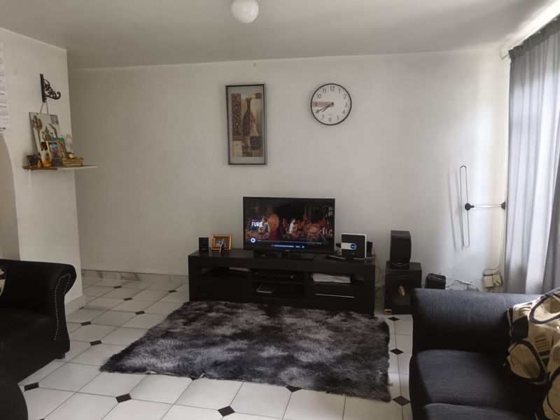 A living room featuring tiled flooring and neutral wall finishes, providing a functional space for relaxation and entertainment.