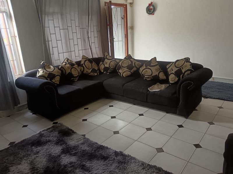 A living room area featuring tiled flooring and access to an exterior security gate.