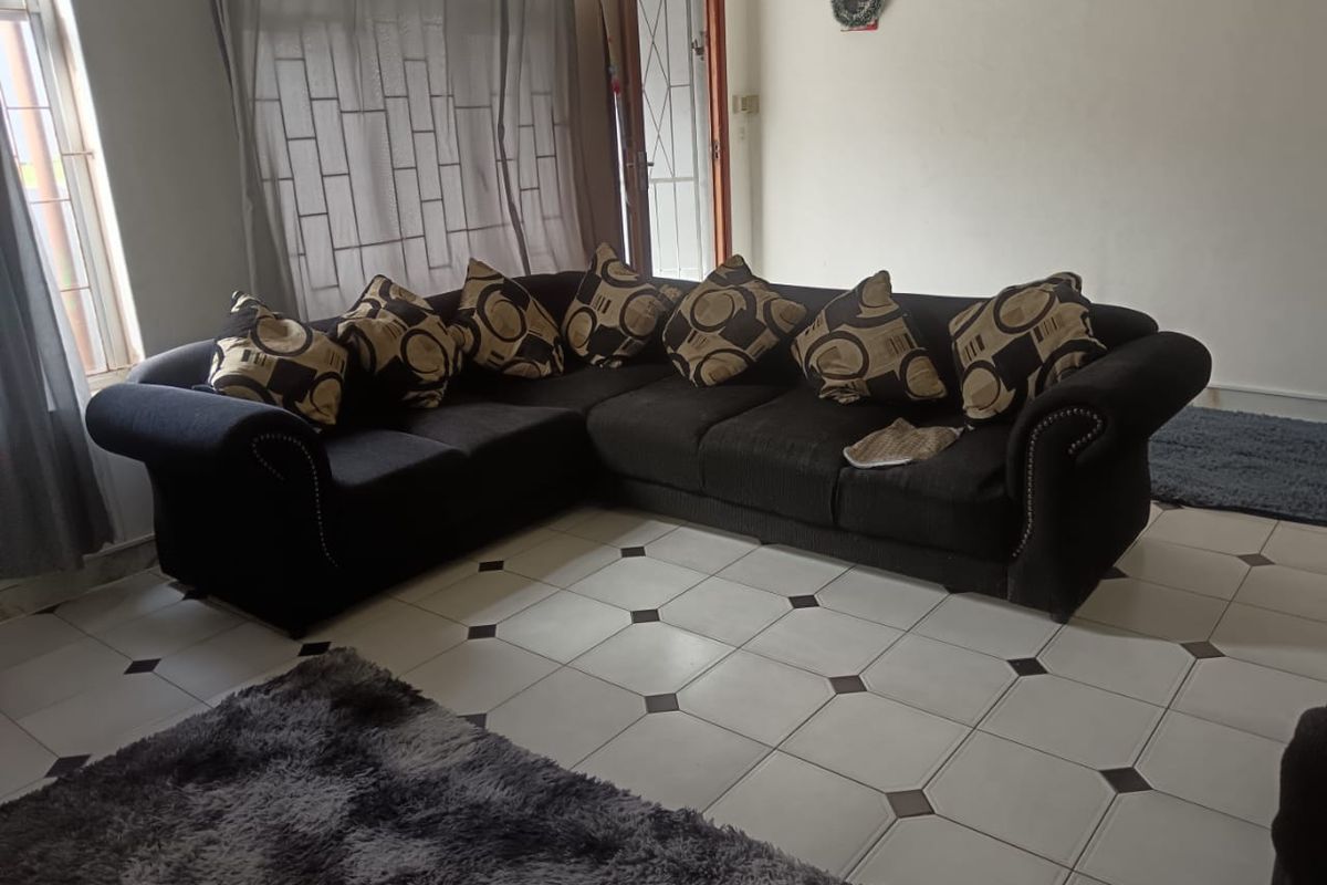 A living room area featuring tiled flooring and access to an exterior security gate.