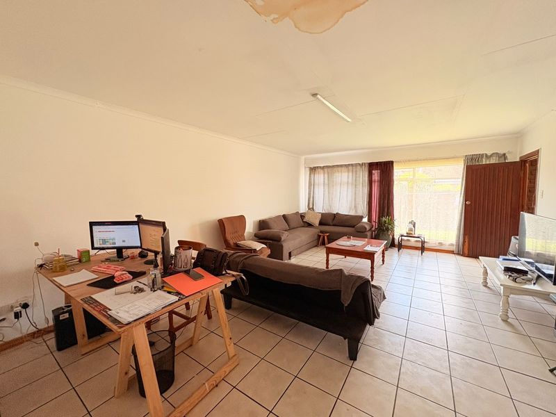 Spacious living area featuring tiled flooring and direct access to the outdoors through a sliding glass door.
