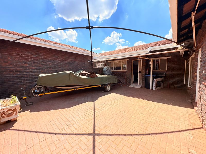 A spacious rear courtyard featuring durable facebrick walls and paved flooring, offering a functional outdoor area with potential for landscaping or patio development.