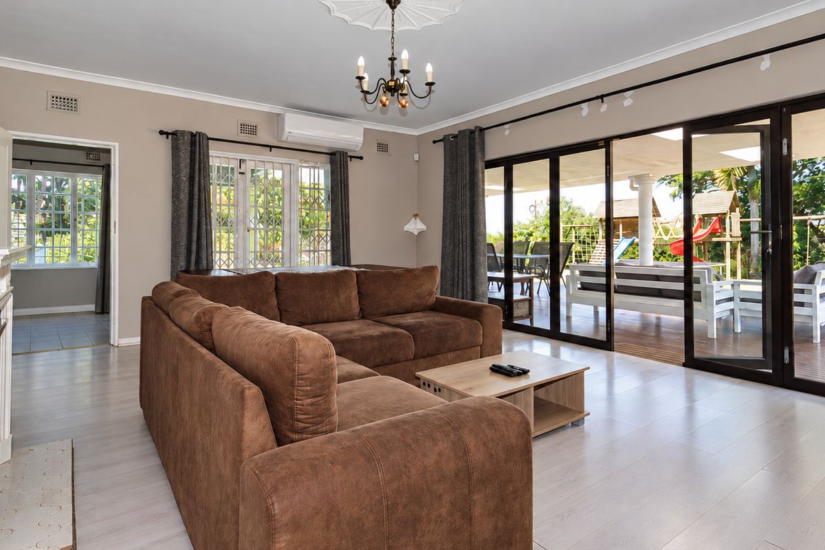 Spacious living room featuring laminate flooring, a fireplace, and large sliding glass doors that provide seamless access to the outdoor patio area.