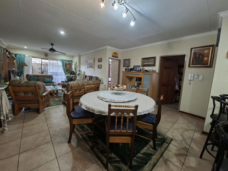 Spacious open-plan living and dining area featuring tiled flooring, ceiling fan, and neutral wall finishes, providing a functional layout for comfortable retirement living.