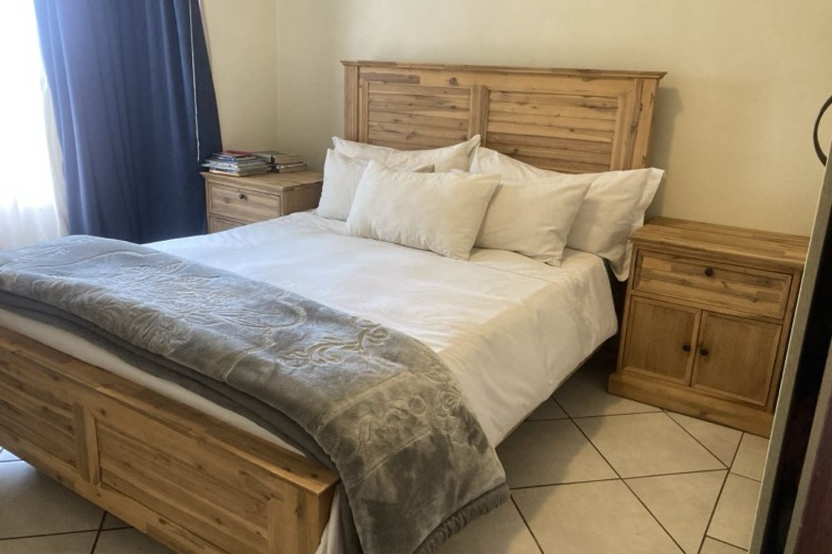A bedroom featuring tiled flooring and neutral wall finishes, providing a functional and comfortable sleeping space.