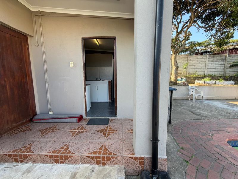 Covered patio area featuring tiled flooring and direct access to an outdoor space with paved surfaces.