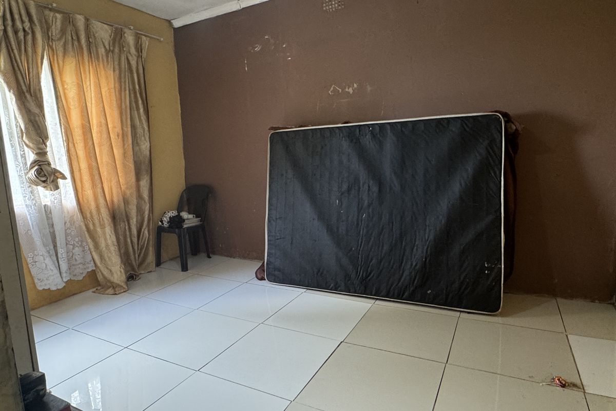 A bedroom featuring tiled flooring and neutral wall finishes, currently vacant and ready for refurbishment.