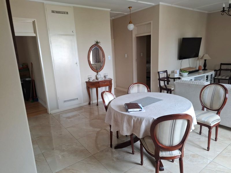 Open plan living and dining area featuring neutral wall tones and polished tiled flooring throughout.