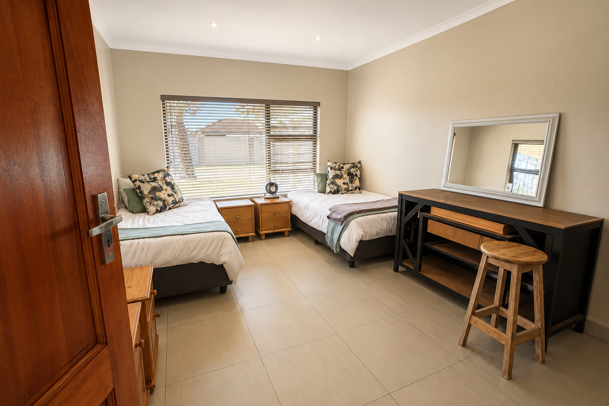 A well-maintained bedroom featuring neutral tiled flooring, recessed downlighting, and large windows fitted with venetian blinds.