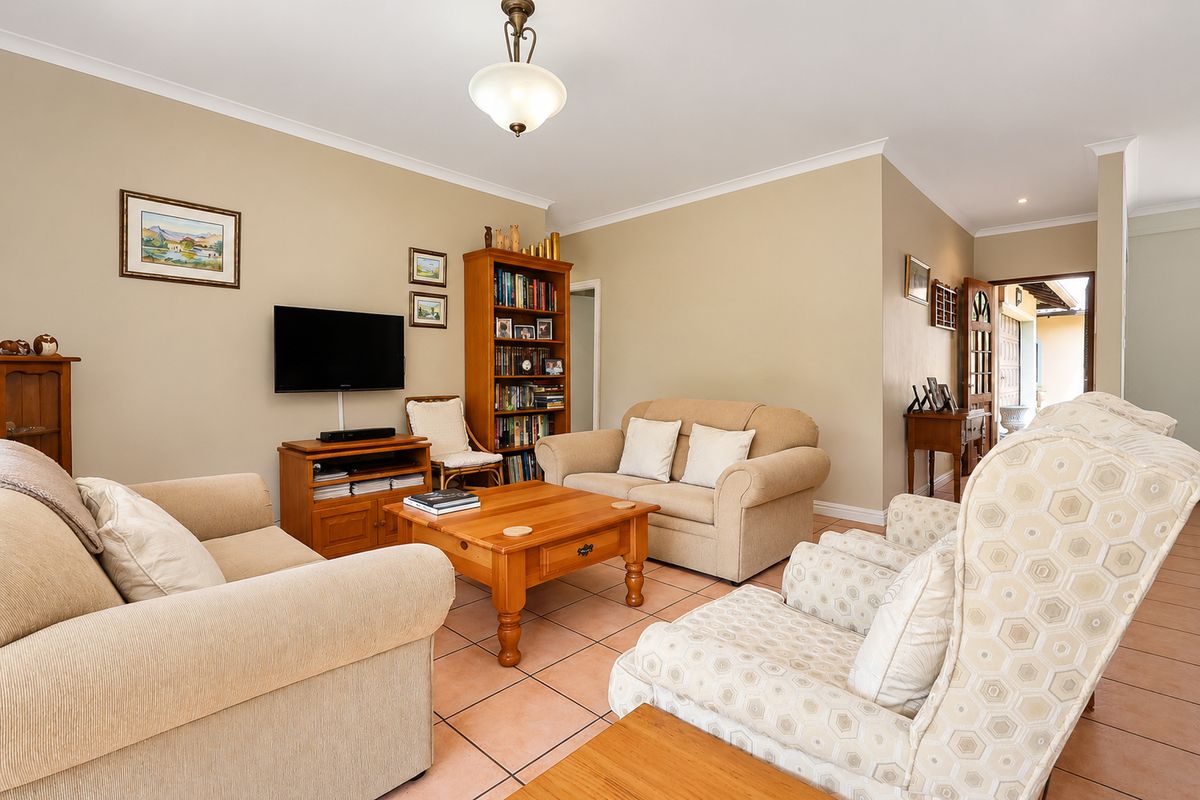 A comfortable living room featuring neutral wall tones, tiled flooring, and a coved ceiling, providing a warm and inviting space for relaxation.