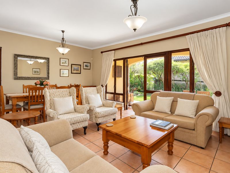 Open plan living and dining area featuring terracotta floor tiles and large sliding glass doors providing direct access to the garden patio.