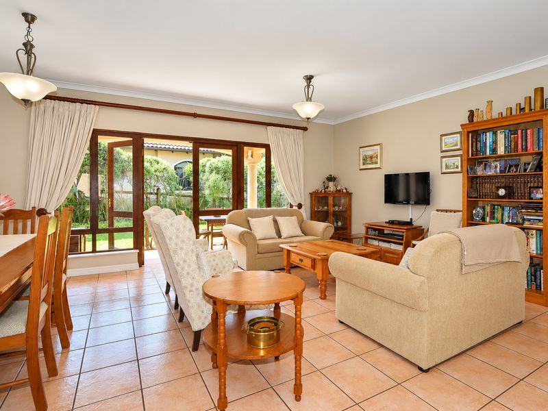 Spacious open-plan living and dining area featuring tiled flooring and large sliding glass doors that provide seamless access to the outdoor patio.