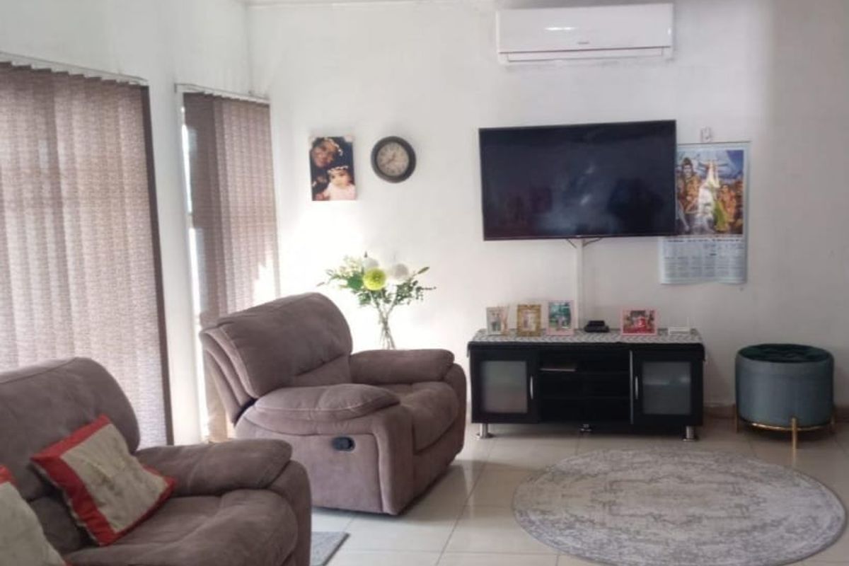 A comfortable living room featuring tiled flooring, vertical blinds, and a wall-mounted split-system air conditioner.
