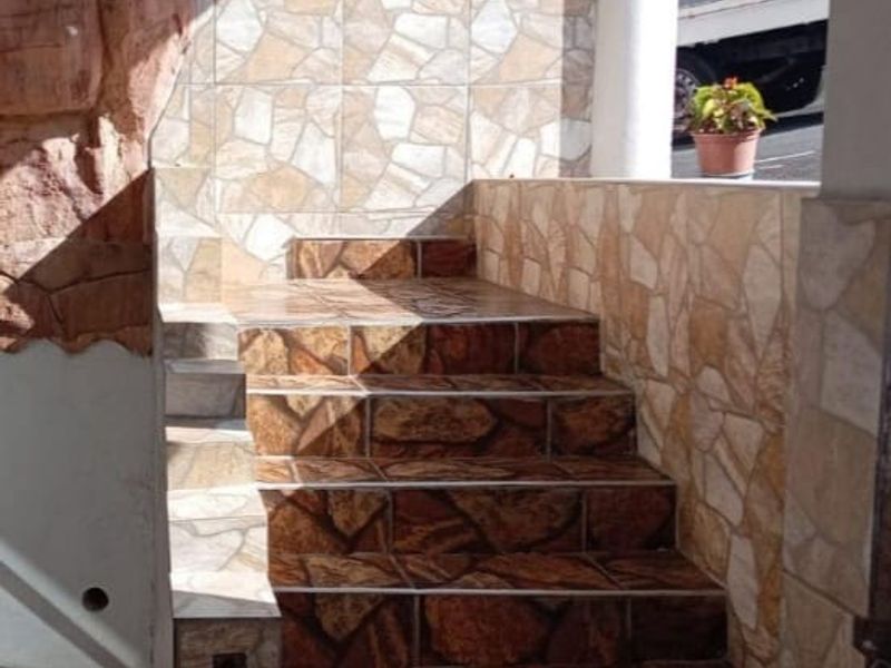 An exterior entrance area featuring a stone-clad staircase and decorative stone wall finishes leading to the property entrance.