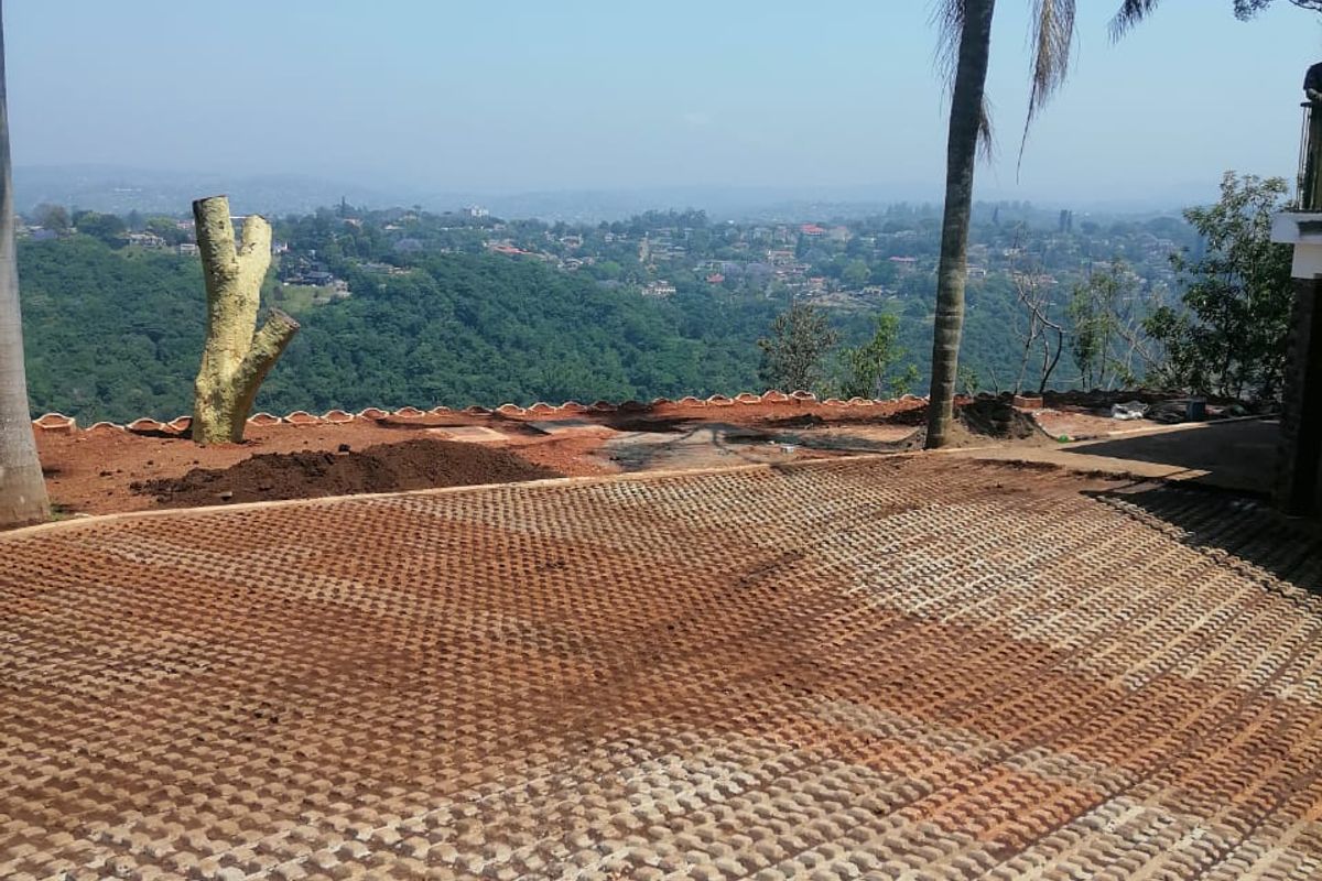 An outdoor area featuring a concrete paver surface with an expansive elevated view of the surrounding landscape and valley.