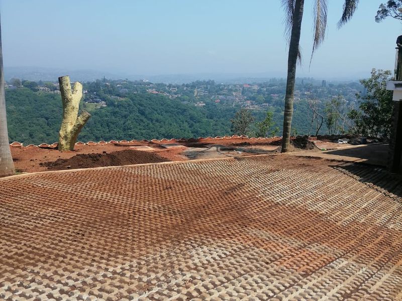 An outdoor area featuring a concrete paver surface with an expansive elevated view of the surrounding landscape and valley.