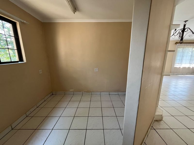 A small, empty utility space featuring tiled flooring and neutral wall paint, offering a functional area for storage or laundry needs.