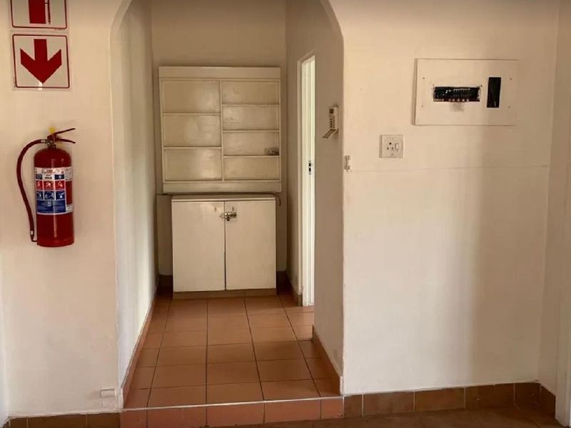 A functional hallway featuring tiled flooring, built-in storage cabinetry, and a wall-mounted electrical distribution board.