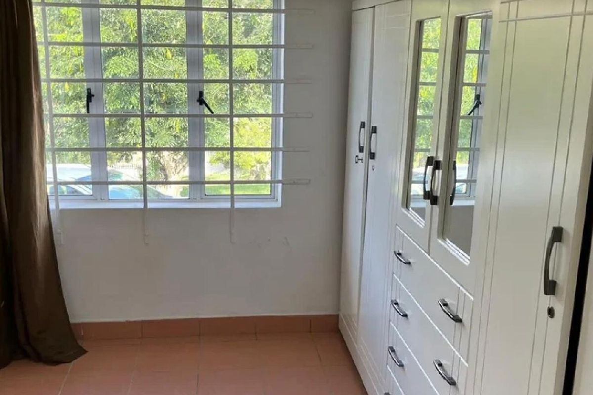 A bedroom featuring tiled flooring, a large built-in wardrobe with mirrored panels, and a window fitted with security bars.