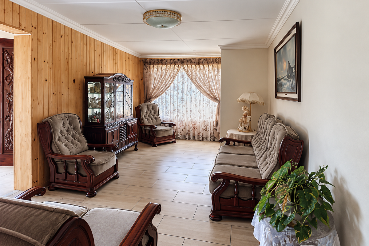 A living room featuring ceramic floor tiles, pine wood wall paneling, and crown molding, offering a traditional aesthetic with potential for modern updates.