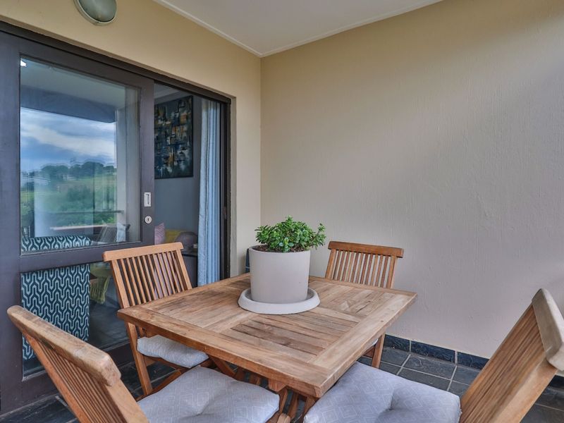 A covered balcony featuring tiled flooring and a large sliding glass door providing access to the interior living space.