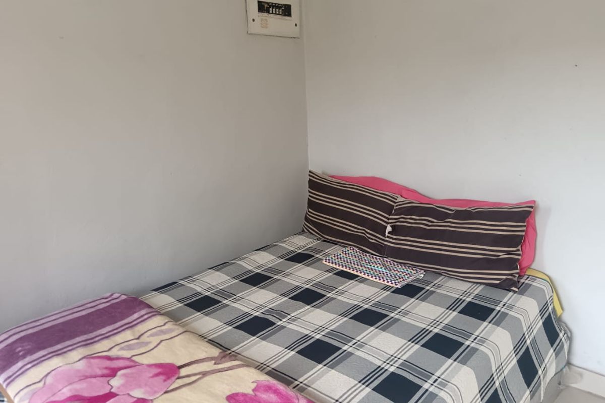 A simple bedroom featuring a wall-mounted electrical distribution board.