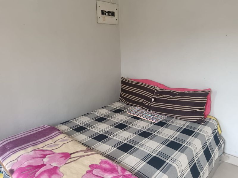 A simple bedroom featuring a wall-mounted electrical distribution board.