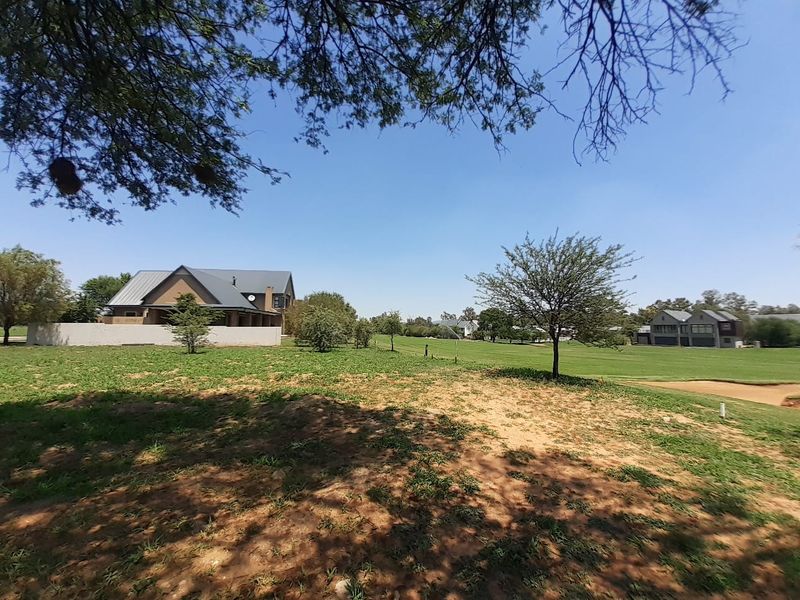 A scenic view of a residential property lot featuring manicured lawns, mature trees, and surrounding neighborhood architecture.