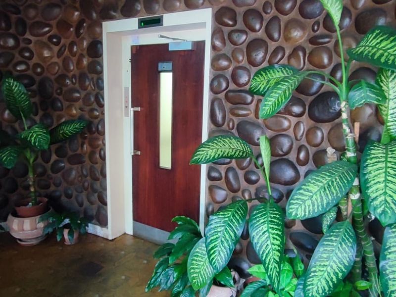 Entrance area featuring a distinctive stone-clad feature wall and a built-in elevator access point.