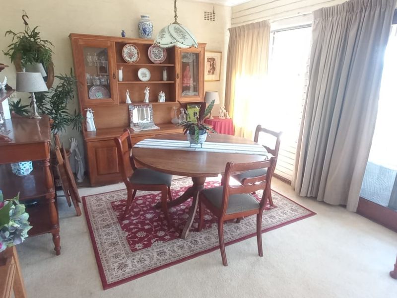 A dining room featuring carpet flooring and large sliding glass doors that provide natural light and access to the exterior.