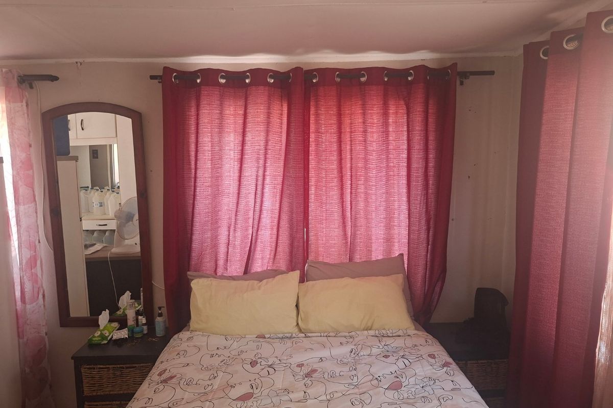 A bedroom featuring red curtains and a neutral wall finish, requiring minor cosmetic updates to improve the overall aesthetic appeal.