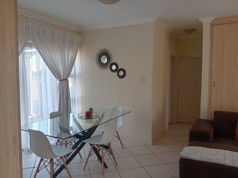 Open plan living and dining area featuring tiled flooring, built-in storage, and a sliding glass door providing access to the exterior.