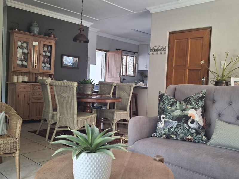 Open plan living and dining area featuring tiled flooring, crown molding, and neutral wall tones, providing a comfortable and connected living space.