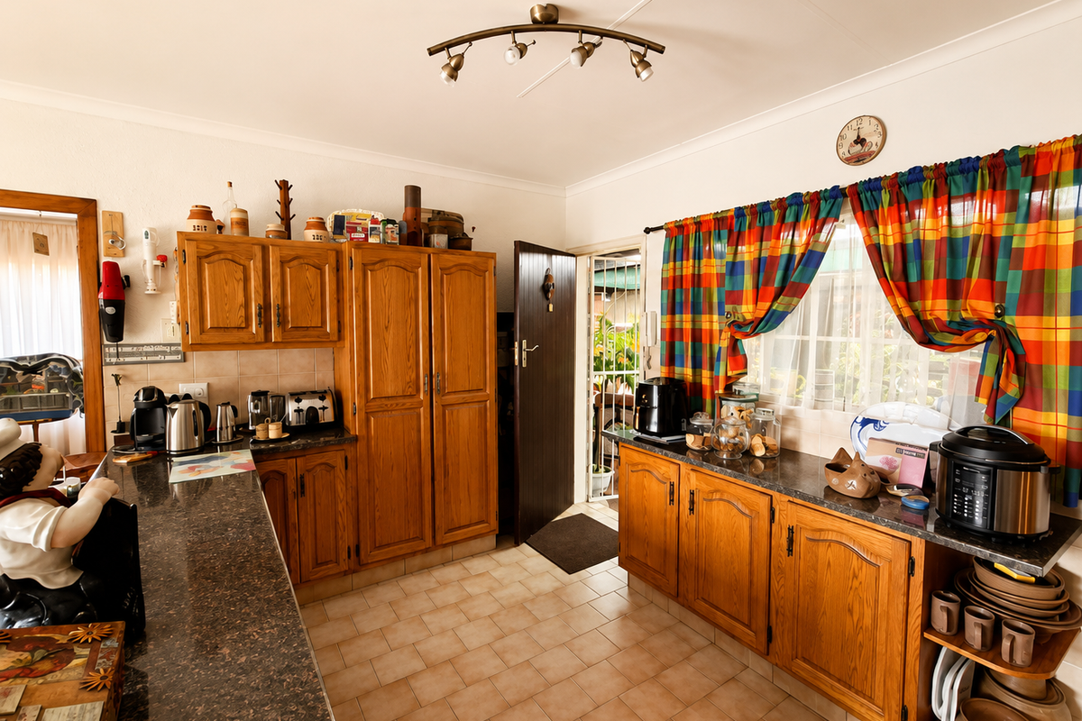 A functional kitchen featuring traditional wooden cabinetry, granite countertops, tiled flooring, and a tiled backsplash, offering a classic layout with direct outdoor access.