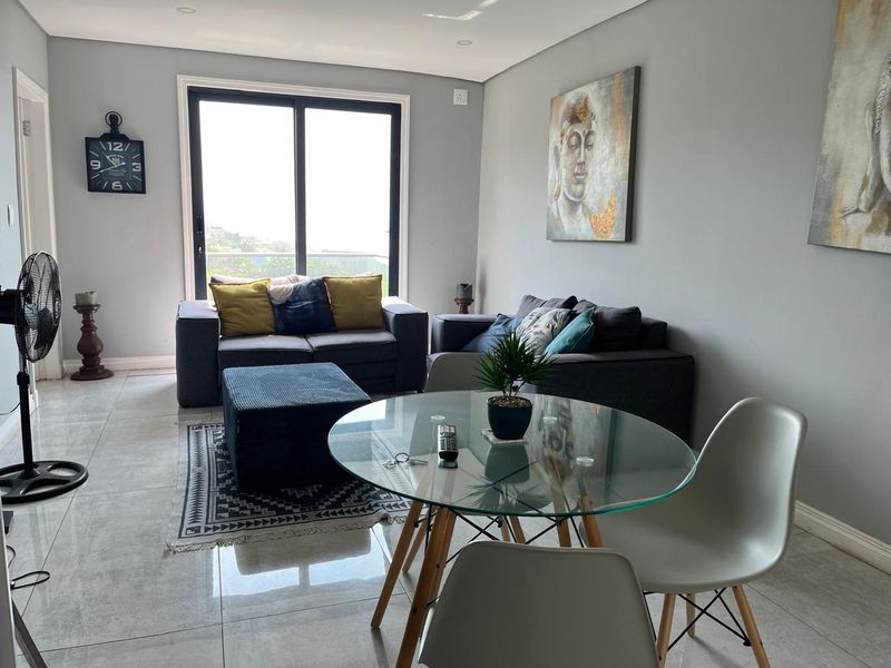 An open-plan living and dining area featuring large sliding glass doors that provide natural light and access to the exterior.