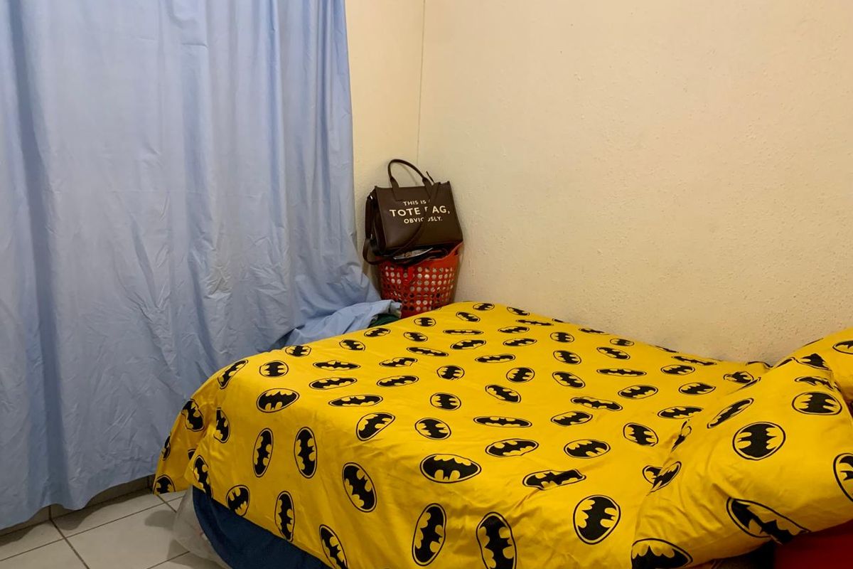 A bedroom featuring tiled flooring and a simple layout, suitable for modernization and updated interior finishes.