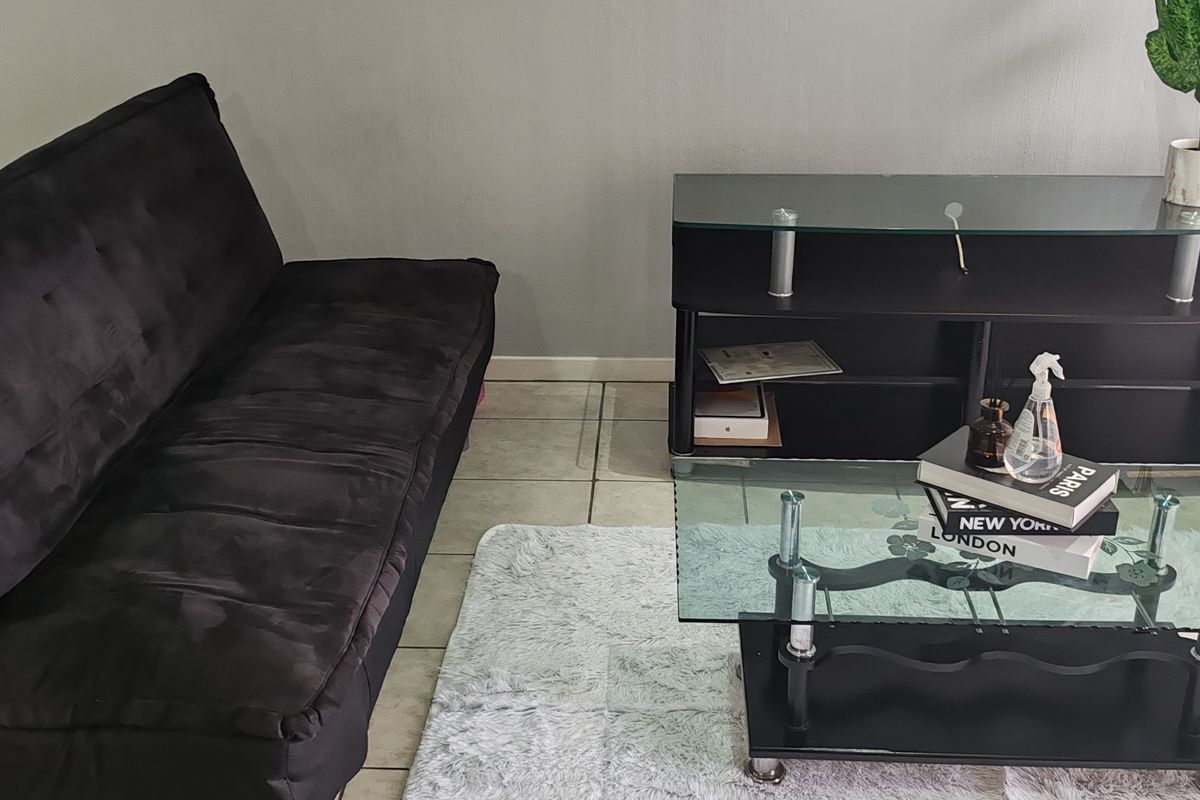 A living room area featuring tiled flooring and neutral wall finishes, providing a functional space for relaxation.