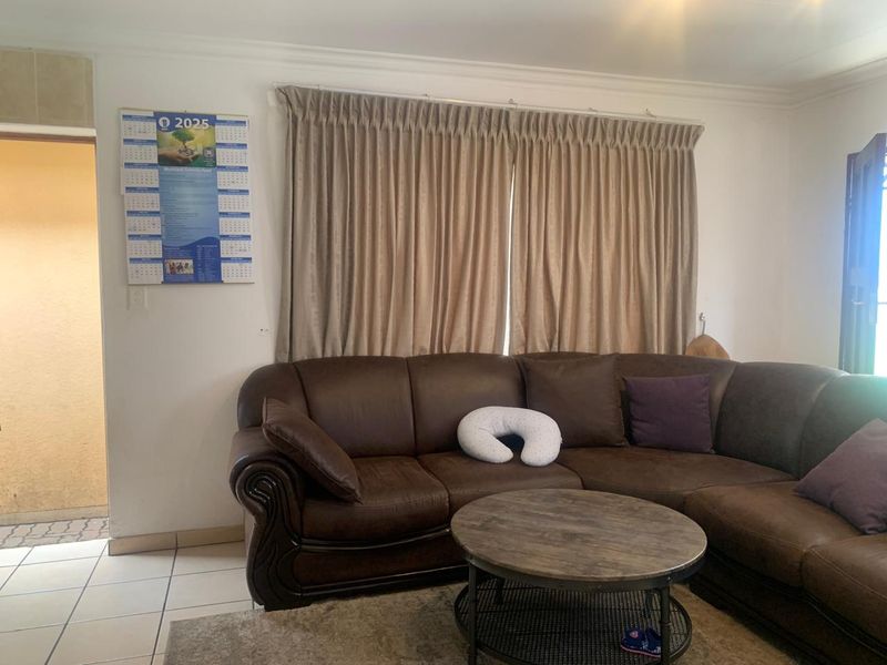 A living room area featuring tiled flooring and neutral wall finishes, providing a functional space for relaxation.