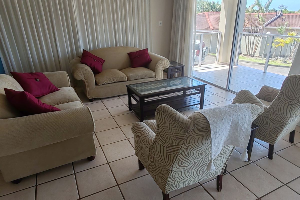 Spacious living area featuring ceramic floor tiles and large sliding glass doors that provide seamless access to the outdoor patio.